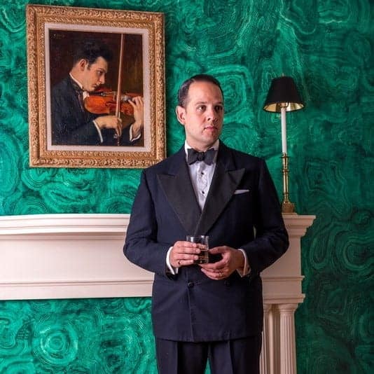 Sven Raphael Schneider in tuxedo in front of green malachite Wall
